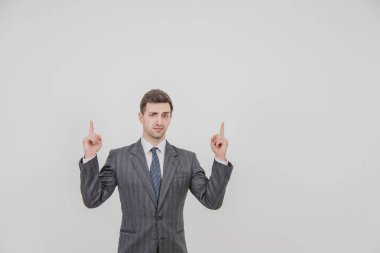 Başarılı yakışıklı işadamı ayakta duruyor, bir proje sunuyor, parmaklarını kaldırıyor, kaşlarını çatıyor..