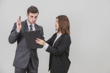 Yakışıklı iş adamı telefonda konuşuyor, belgelere bakıyor. Sekreter elinde not panosuyla patron imzasını bekliyor..