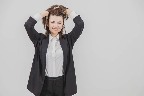 Mulher de negócios bonita de pé, correndo as mãos através de seu cabelo, sorrindo . — Fotografia de Stock