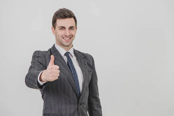 Handsome businessman standing, giving thumb up, smiling, showing his satisfaction. — Stock Photo, Image