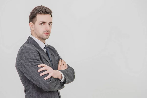 Serious confident handsome businessman standing camera right, his hands folded. — Stock Photo, Image