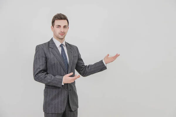 Successful handsome businessman standing, presenting a project, pointing his hands at the copyspace for text or product. — Stock Photo, Image