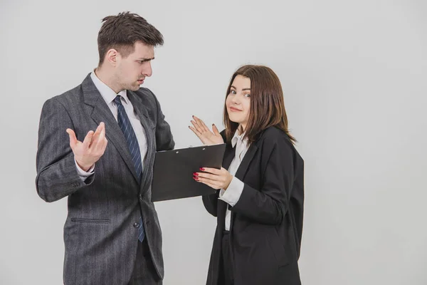 Niedliche junge Sekretärin brachte Dokument, das Chef muss unterschreiben, aber er versteht nicht und will nicht unterschreiben, runzelt die Stirn. — Stockfoto