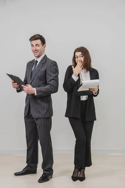 Business man and woman standing alongside, holding clipboards with documents. — Stock Photo, Image