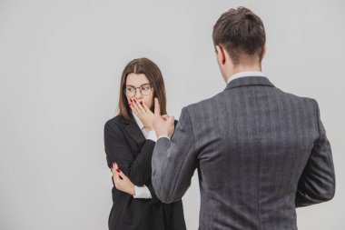 Patron ve sekreter ciddi bir konuşma yapıyorlar. Katı patron genç çalışanını parmağıyla tehdit ediyor..