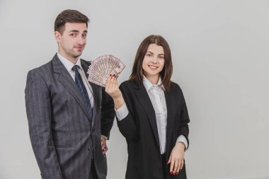 Mutlu ve varlıklı, kendine güvenen bir çift. İnsan eli akimbo ile ayakta duruyor. Onun tarafındaki kadın elinde bir dolar banknotları hayranı, dikkatsizce gülümsüyor..