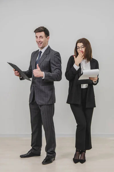 Hombre y mujer de negocios de pie a su lado, sujetando portapapeles con documentos . —  Fotos de Stock