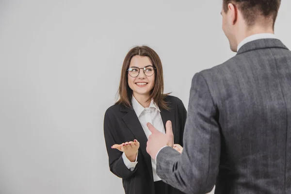 Exciting conversation of two successful business people. Man standing back to the camera. Blurred forefront. — Stock Photo, Image