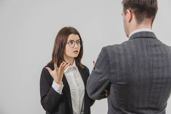 Två affärspartners har ett uttrycksfullt samtal. Arg kvinna skriker på mannen, gör galna ansiktsuttryck och rörelser. — Stockfoto