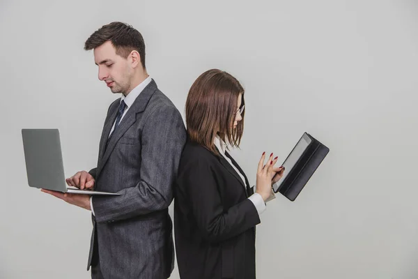 Працездатні успішні робочі партнери стоять на плечі, перевіряючи дані. Чоловік, що працює з ноутбуком, жінка з планшетом . — стокове фото