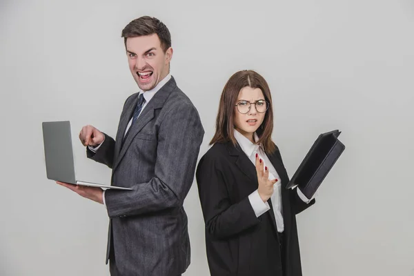 Busy successful work partners standing shoulder to shoulder, checking data. Man working with laptop, looking with irritated face expression, woman with tablet, woman asking for silence . — Stock Photo, Image