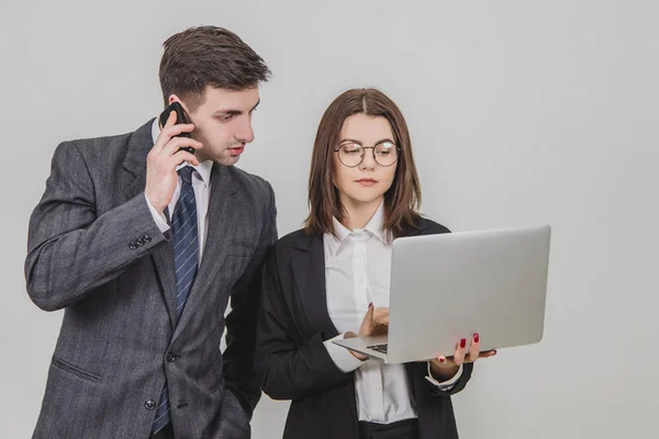 Бизнесмен держит ноутбук, проверяет данные. Мужчина на ее стороне говорит по телефону, смотрит на то, что эта женщина показывает в ноутбуке . — стоковое фото