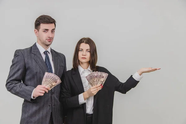 Mann und Frau stehen mit Banknotenfächern in der Hand. Frau zeigt auf den Kopierraum auf ihrer Seite. — Stockfoto