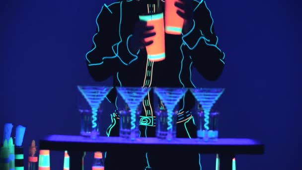 Barmannen laten zien. Optreden. Barman mengt en giet alcohol in glas, op een helderblauwe achtergrond. Langzame beweging. 4k. — Stockvideo