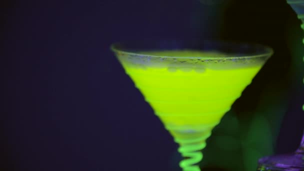Feche o copo de coquetel, que está cheio de bebida e gelo seco no bar. Espetáculo fabuloso. Luzes coloridas conduzidas. Movimento lento. 4K . — Vídeo de Stock