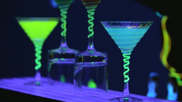 Close up Cocktailgläser, die voll mit Getränken und Trockeneis an der Bar sind. Barmann gießt Alkohol in Gläser. Fabelhafte Show. Bunte Lichter führten. Zeitlupe. 4k. — Stockvideo