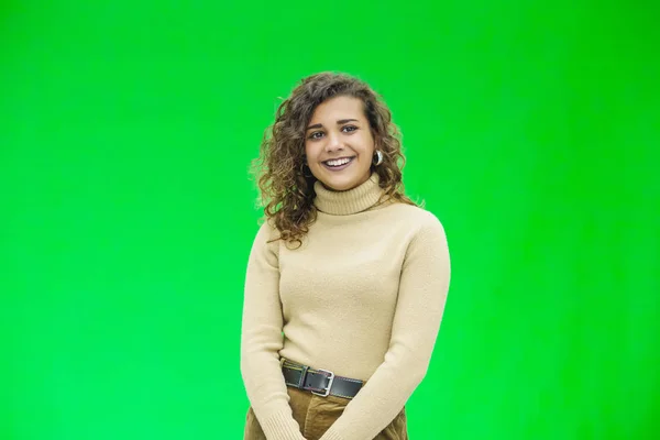 Menina brilhante posando no fundo verde, olhando positivo, sorrindo . — Fotografia de Stock