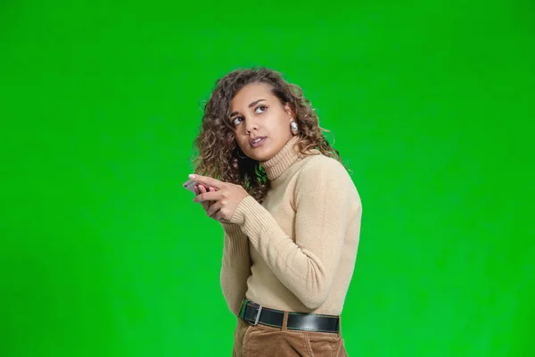 Bonito adolescente viciado no telefone inteligente isolado em um fundo verde . — Fotografia de Stock