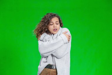 Güzel bir kadın kendini kalın bir kazakla kapatıyor, ama hala soğuk ve titriyor..