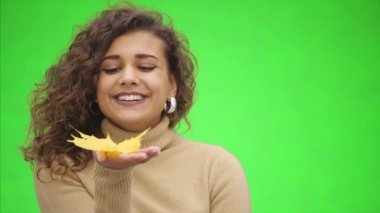 Çekici Afro-Amerikalı kız geniş bir kesime gülümsüyor. Kız küçük bir sonbahar tatili yapıyor. Sonbaharın güzelliğini gösteriyor. Kapatın. Boşluğu kopyala.