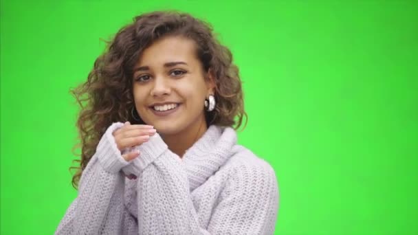 Attraente afro-americana ragazza sta sorridendo ampiamente. Si sta scaldando le dita, indossando un maglione bianco. Chiudete. Copia spazio . — Video Stock