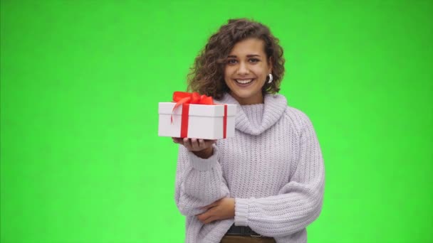Mulher afro-americana está segurando caixa de presente com fita vermelha e está dando a você. Felicidades. Fecha. Espaço de cópia . — Vídeo de Stock