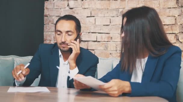 Zwei Geschäftsleute arbeiten in einem Café. Sie diskutieren und bereiten den Vertrag vor. Mann telefoniert gleichzeitig. Nahaufnahme. Kopierraum. — Stockvideo