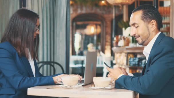 Dos hombres de negocios tienen almuerzo de negocios. El hombre gracioso en un restaurante o una cafetería está bebiendo café. Copiar espacio . — Vídeo de stock