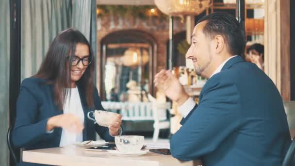 两个商人握手,他们吃着商务午餐. 在餐馆或咖啡店里的女人和男人在搅拌和喝咖啡。 复制空间. — 图库视频影像