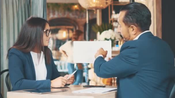 Due uomini d'affari lavorano in un bar. Stanno discutendo e preparando il contratto. Chiudete. Copia spazio . — Video Stock