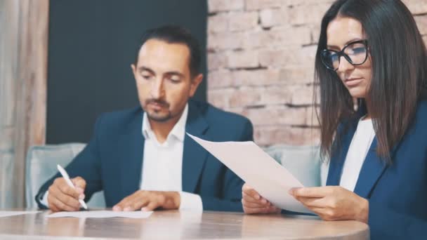 Two businesspeople work in a cafe. They are discussing and preparing the contract. Boss is signing documents. Close up documents. Crop. Copy space. — 비디오