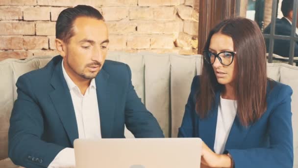 Два бізнесмени в глибоких синіх костюмах обговорюють питання, сидячи в кав'ярні. Копіювати простір . — стокове відео