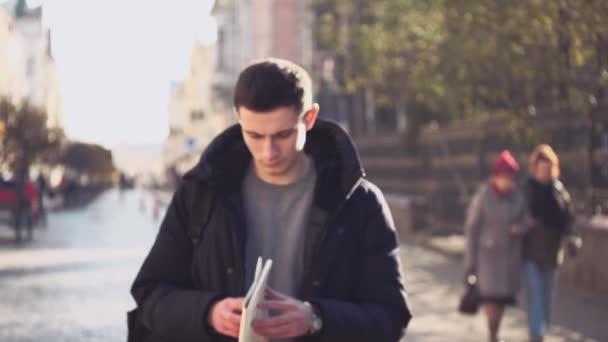 El chico guapo está paseando y aprendiendo el mapa. Perdido en una ciudad extranjera. Acción. Animación. 4K . — Vídeo de stock