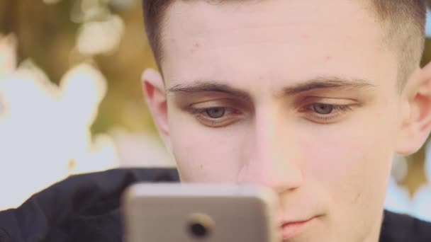 Close up. Handsome young man is using cellphone outdoors in the city. Action. Animation. 4K. — Stok video