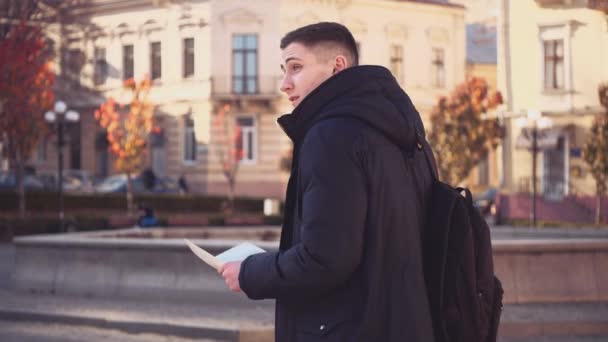 Snygg kille vilse i en främmande stad. Förvirrad ansiktsuttryck. Uppfattat utrymme. Börja. Animering. 4k. — Stockvideo