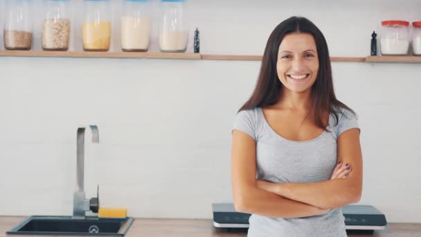 Tareas domésticas. Mujer bonita está sonriendo sinceramente, estar en el fondo de la cocina. Copiar espacio. De cerca. 4K . — Vídeo de stock