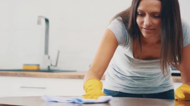 La mujer con guantes de goma amarillos está limpiando el panel de cocina en la cocina con un spray removedor de grasa y un plumero. Cultivo. Copiar espacio. De cerca. 4K . — Vídeos de Stock