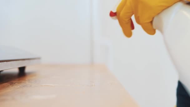 Mulher em luvas de borracha amarela está limpando o painel de cozinha na cozinha com spray removedor de gordura e um pano. Cultivo. Espaço para cópia. Fecha. 4K . — Vídeo de Stock