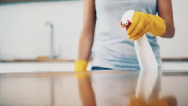 Жінка в жовтих гумових рукавичках прибирає панель для приготування їжі на кухні з жирним розпилювачем і тканиною. Врожай. Копіювати простір. Близько. 4-кілометровий . — стокове відео