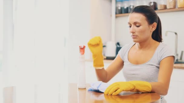 Kobieta w żółtych gumowych rękawiczkach jest zmęczona sprzątaniem kuchni sprayem do usuwania tłuszczu. Zamknij drzwi. 4k. — Wideo stockowe