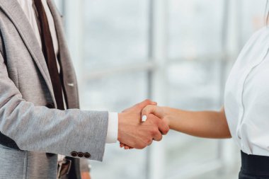 Cropped shot of business people shaking hands, greeting one another with successful deal and signing a contract. clipart