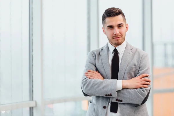 Joven empresario confiado de pie con las manos dobladas, mirando a la cámara, listo para el día de trabajo duro . — Foto de Stock