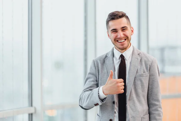 Empresário de sucesso com polegares para cima comemorando sua vitória, sorrindo para a câmera . — Fotografia de Stock