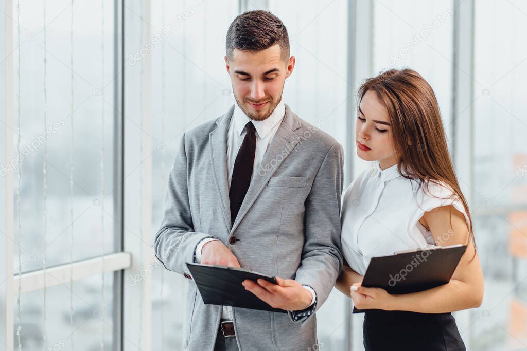 Businessman and woman analyzing investment charts and market perspectives.