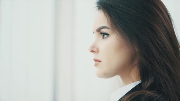 Business woman is calm, looking at the camera, isolated on white blurred background. Close up. Copy space. 4K. — Stok video