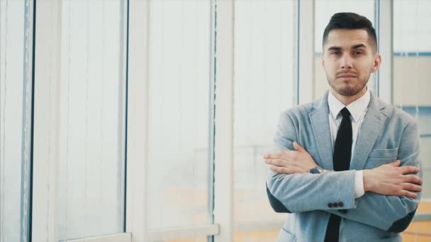 El hombre de negocios es serio con las manos cruzadas o dobladas mientras posa, aislado sobre fondo panorámico blanco. Copiar espacio. 4K . — Vídeos de Stock