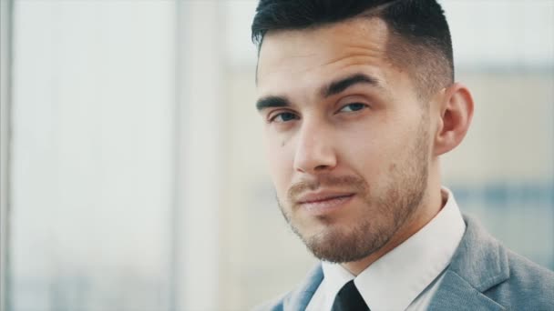 Homme d'affaires donnant un sourire, isolé sur fond panoramique blanc. Ferme là. Espace de copie. 4K . — Video