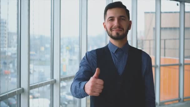 Hombre de negocios exitoso está mostrando su dedo pulgar upgesture, en el fondo del panorama de la luz. Un hombre aislado. 4K . — Vídeo de stock