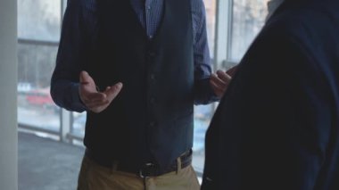 Crop. Male business workers are discussing issues. Copy space. Men are shaking hands. Successful agreement. Blurred background. Close up. 4K.