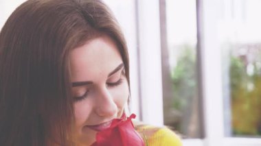 Güzel esmer kız bir kafede gül kokusu alıyor. Kapatın. Ekin. Uzayı kopyala 4k.